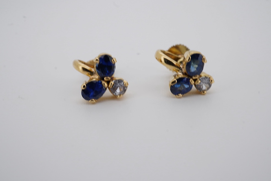 A modern pair of yellow metal and three stone blue and white sapphire cluster set ear clips, approx. 8mm, gross weight 3 grams. Condition - poor to fair